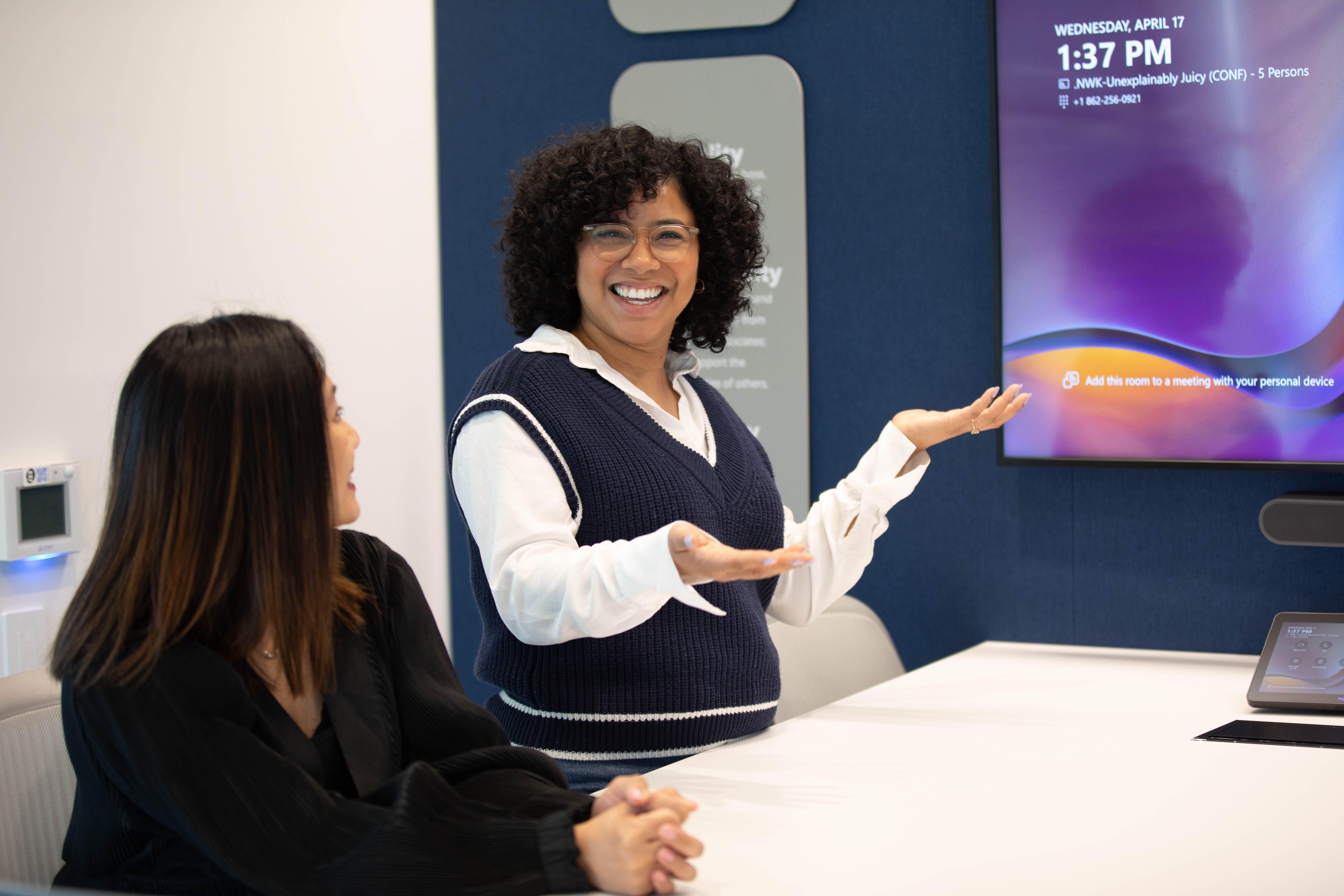 Woman smiling in the office next to a colleague