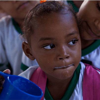 Child under 12 years of age drinking from a blue cup